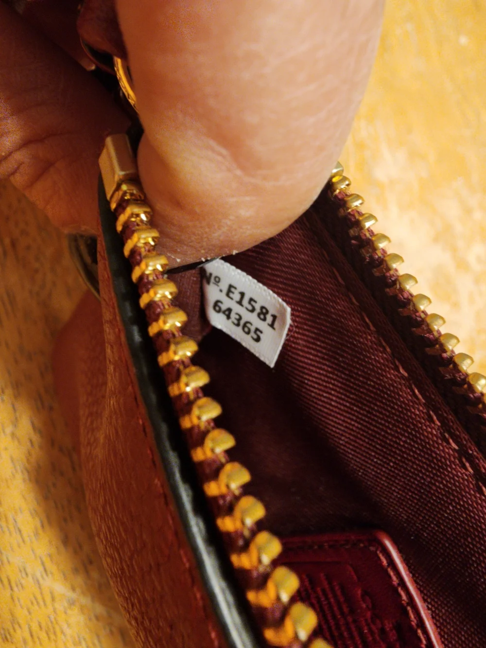 red polished pebble leather Coach wristlet, featuring gold-tone hardware